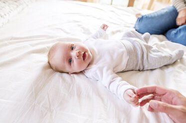 Baby mit Eltern im Bett liegend - HAPF000477