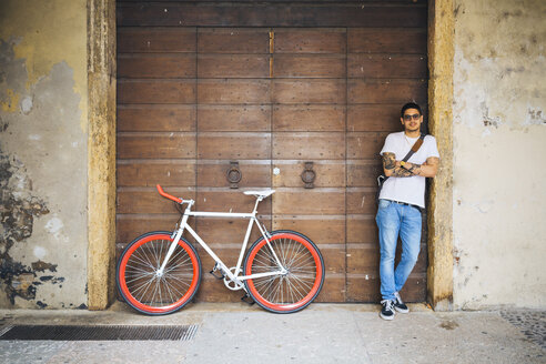 Junger Mann mit einem Fahrrad in der Stadt - GIOF001161