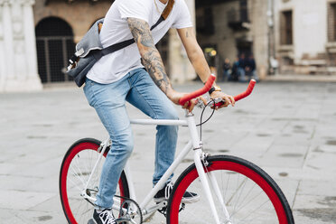 Junger Mann fährt Fahrrad in der Stadt - GIOF001177