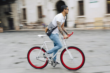 Young man riding bicycle in the city - GIOF001178