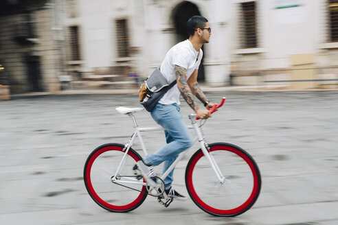 Junger Mann fährt Fahrrad in der Stadt - GIOF001178