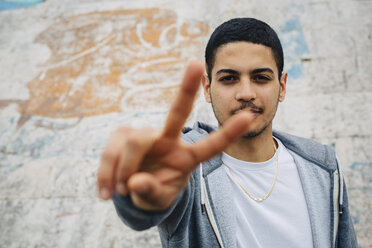 Young man showing victory sign - GIOF001205