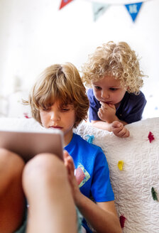 Zwei kleine Brüder benutzen ein Tablet zu Hause - MGOF001899