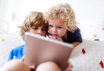 Two little brothers using tablet at home - MGOF001902