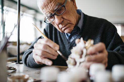 Senior man decorating ceramic in his spare time - JRFF000698