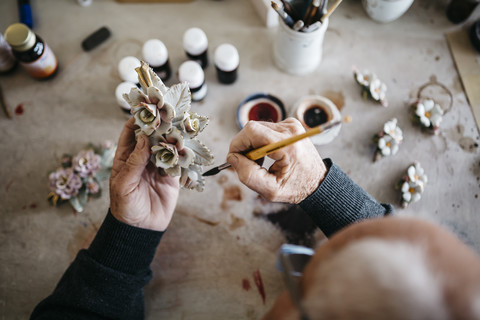 Senior man decorating ceramics in his spare time stock photo