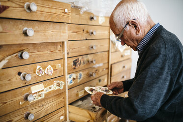 Älterer Mann sucht Abziehbilder für Keramiken - JRFF000702