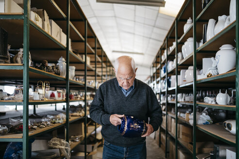 Elderly man reviewing the ceramic piece - JRFF000704