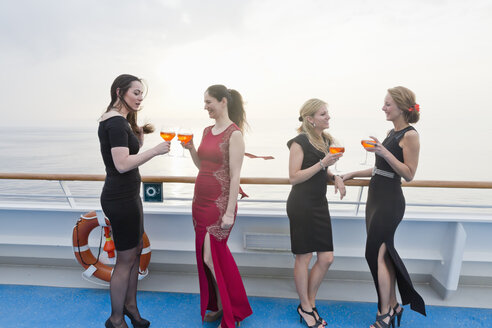 Vier Frauen mit Aperitifs stehen an Deck eines Kreuzfahrtschiffes - ONBF000026