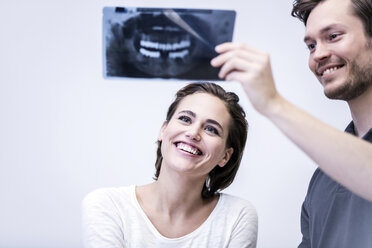 Zahnarzt und Patient beim Betrachten eines Röntgenbildes - FMKF002598