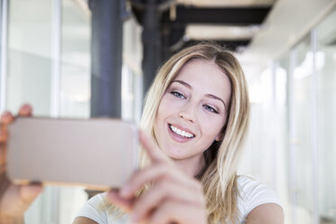 Blond woman at the dentist's taking selfie of bleached teeth - FMKF002604