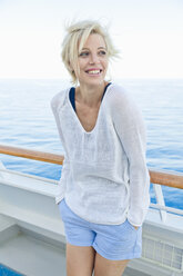 Porträt einer blonden Frau, die an der Reling eines Kreuzfahrtschiffs steht - ONBF000034