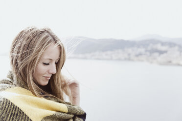 Porträt einer blonden, mit einer Decke bedeckten Frau auf dem Deck eines Kreuzfahrtschiffs - ONBF000035