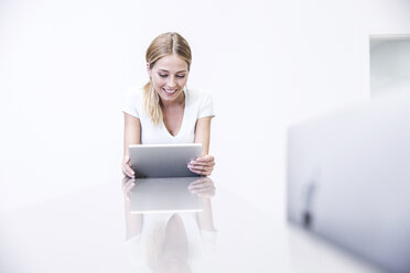 Blond woman using digital tablet - FMKF002677