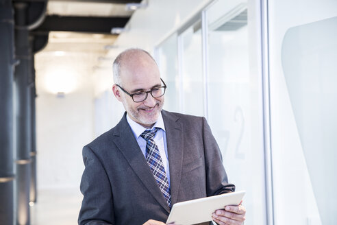 Älterer Geschäftsmann mit digitalem Tablet - FMKF002683