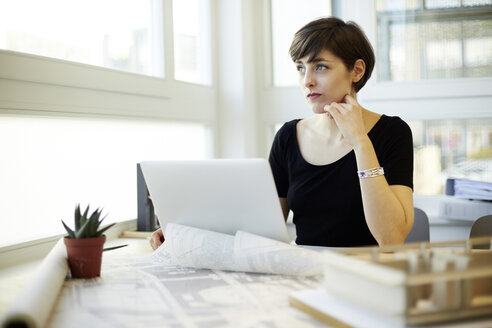 Architekt sitzt am Schreibtisch und schaut durch das Fenster - TSFF000037