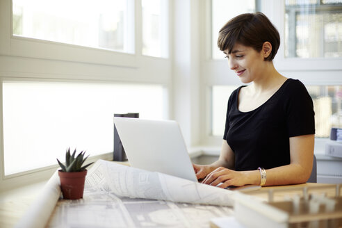 Porträt einer jungen Architektin mit Laptop in ihrem Büro - TSFF000039