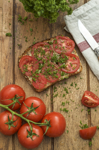 Scheibe Körnerbrot garniert mit Tomate und Petersilie, lizenzfreies Stockfoto