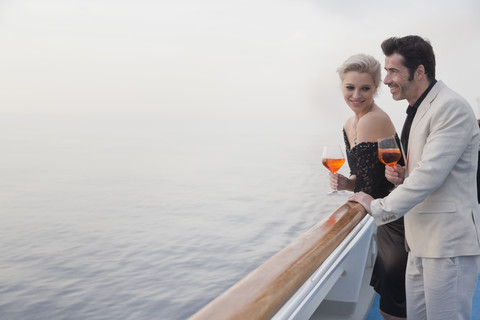 Couple with aperitive leaning on railing of a cruise liner stock photo