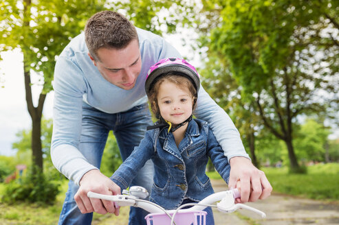 Father accompanying daughter on bike - HAPF000484