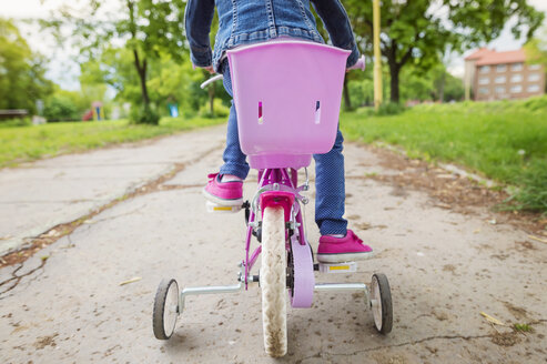 Mädchen fährt Fahrrad mit Stützrädern - HAPF000485