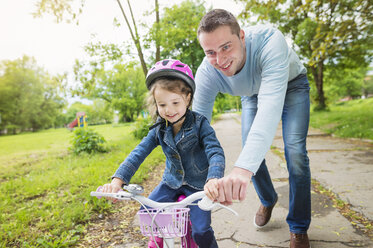 Father accompanying daughter on bike - HAPF000486