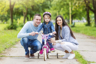 Lächelnde Eltern mit Tochter auf dem Fahrrad - HAPF000490
