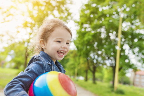 Glückliches Mädchen hält Ball im Park - HAPF000494