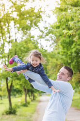 Father playing with daughter in park - HAPF000496