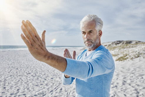 Porträt eines Mannes, der am Strand Tai Chi übt - RORF000208