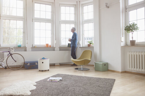 Älterer Mann zu Hause, der aus dem Fenster schaut - RBF004546