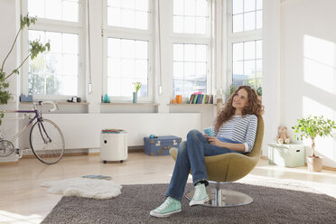 Relaxed woman at home sitting in chair - RBF004554