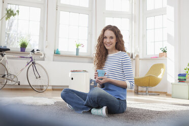 Smiling woman at home sitting on floor - RBF004561