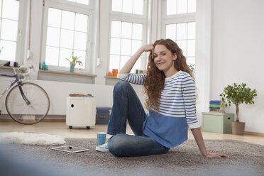 Smiling woman at home sitting on floor - RBF004565