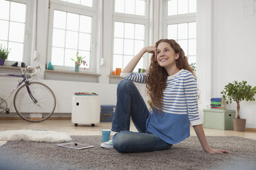 Smiling woman at home sitting on floor - RBF004566