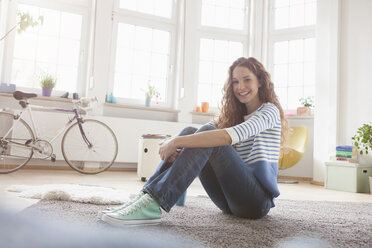 Lächelnde Frau zu Hause auf dem Boden sitzend - RBF004567