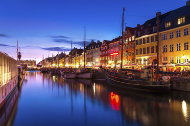 Denmark, Copenhagen, view of historic boats and row of houses at Nyhavn in the evening - PUF000525