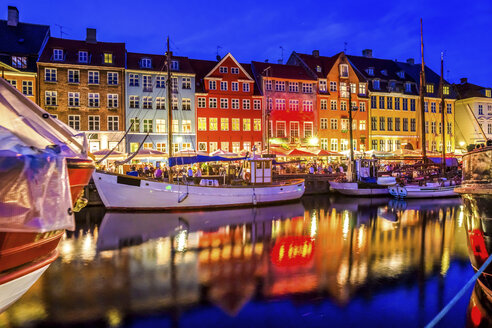 Denmark, Copenhagen, view of historic boats and row of houses at Nyhavn in the evening - PUF000526