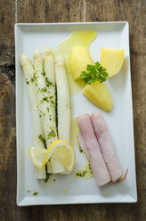 White asparagus with cooked ham, potatoes and butter parsley sauce on plate - ODF001384