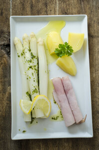 Weißer Spargel mit gekochtem Schinken, Kartoffeln und Butter-Petersilien-Sauce auf Teller - ODF001384