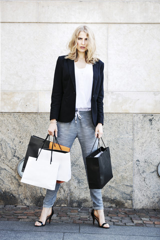 Portrait of serious looking woman with many shopping bags stock photo