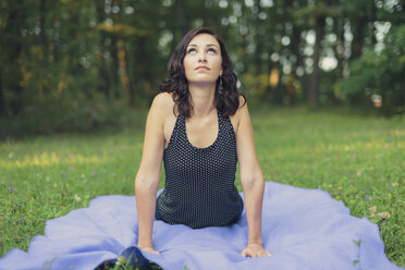 Photo of young woman in long green dress doing yoga in forest Stock Photo -  Alamy