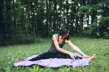 Junge Frau, die sich in der Natur ausstreckt, Yoga in der Natur - LCU000006