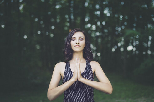 Young woman meditating with closed eyes in the forest, yoga in nature - LCU000007