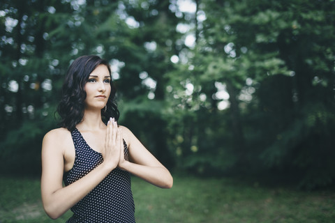 Junge Frau meditiert im Wald, Yoga in der Natur, lizenzfreies Stockfoto