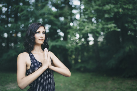 Young woman meditating in the forest, yoga in nature stock photo