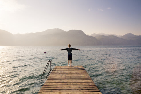Italy, Brenzone, back view of boy standing on jetty - LVF004911