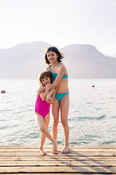 Italy, Brenzone, two little sister standing on jetty - LVF004913