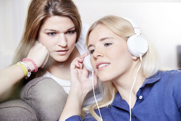 Two young women listening music together - FMKF002698