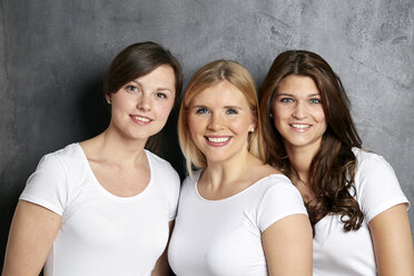 Gruppenbild von drei lächelnden Freunden - FMKF002702